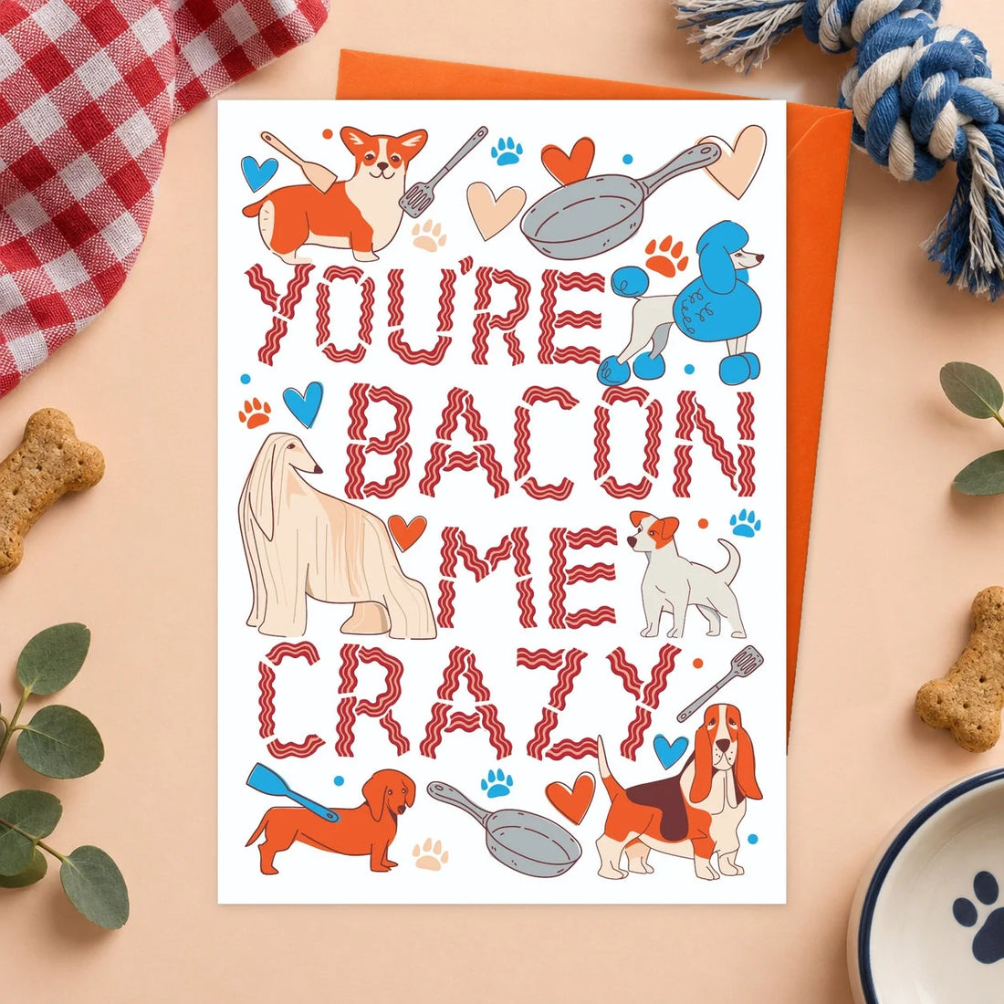 Bacon Me Crazy – Edible Dog Card, bacon flavour by Scoff Paper, shown with an orange envelope