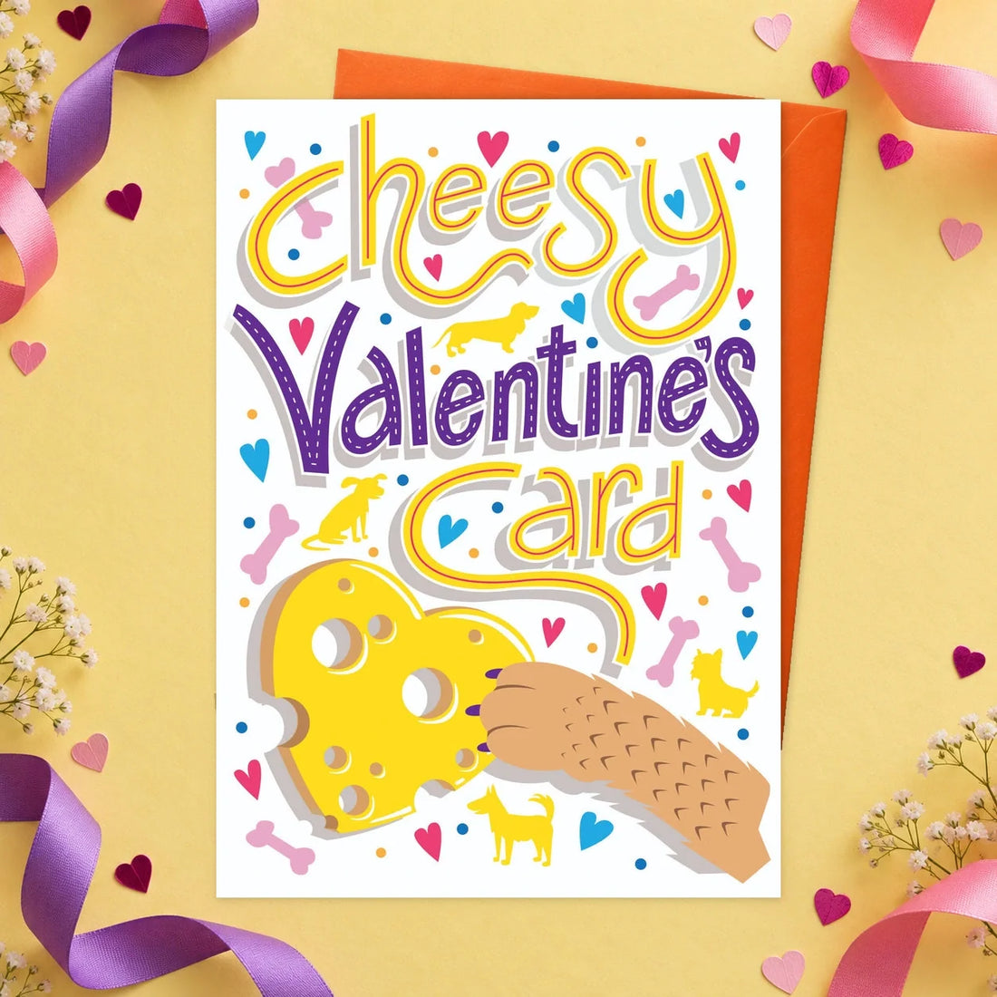 Cheesy Valentines – Edible Dog Valentine’s Day Card, cheese flavour by Scoff Paper, shown with an orange envelope