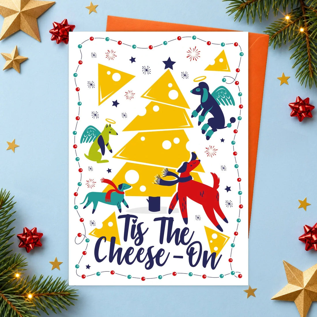 Tis the Cheese-on – Edible Dog Christmas Card, cheese flavour by Scoff Paper, shown with an orange envelope