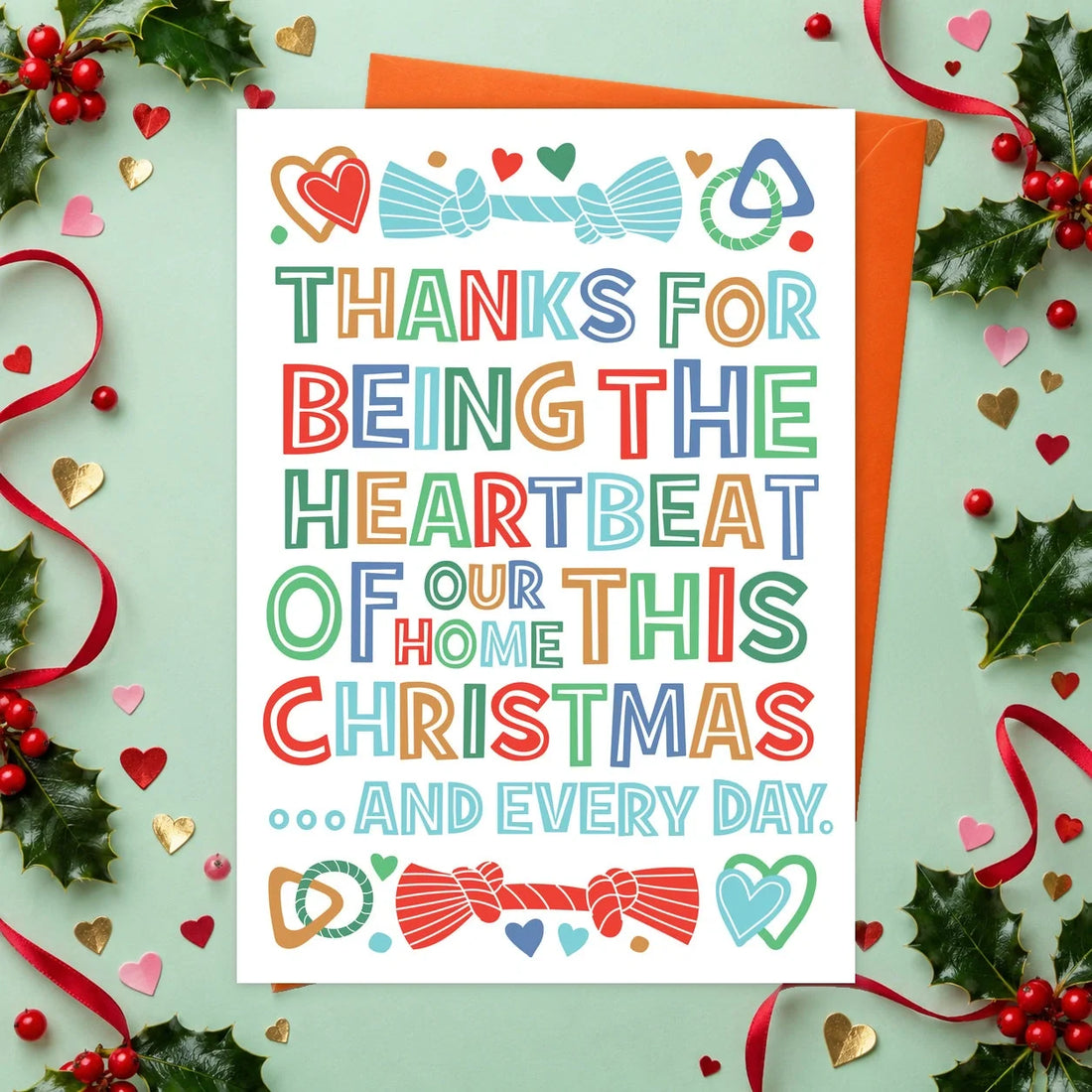Heartbeat of Our Home – Edible Dog Christmas Card, chicken flavour by Scoff Paper, shown with an orange envelope