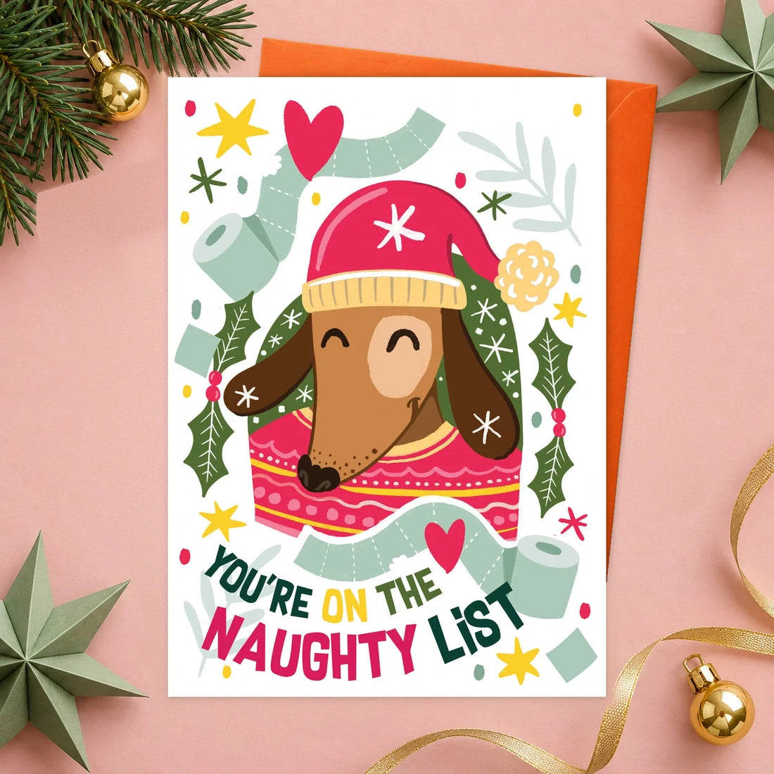Naughty List – Personalised Edible Dog Christmas Card, bacon flavour by Scoff Paper, shown with an orange envelope