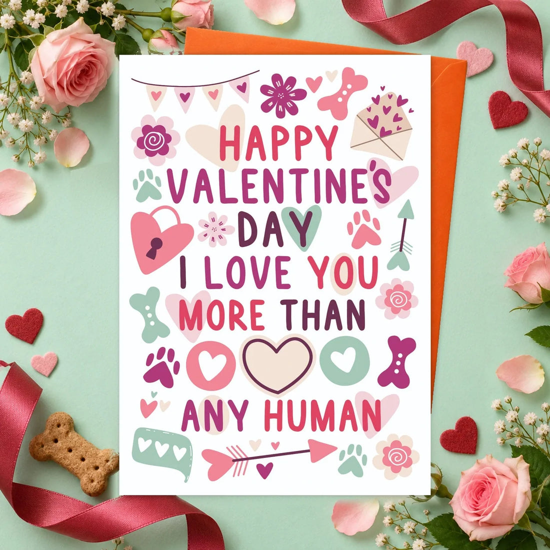 Love You More – Edible Dog Card, bacon flavour by Scoff Paper, shown with an orange envelope